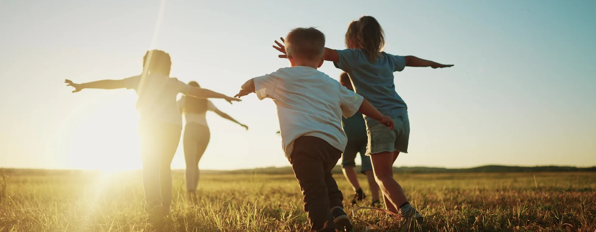 Enfants courant dans un champ ensoleillé