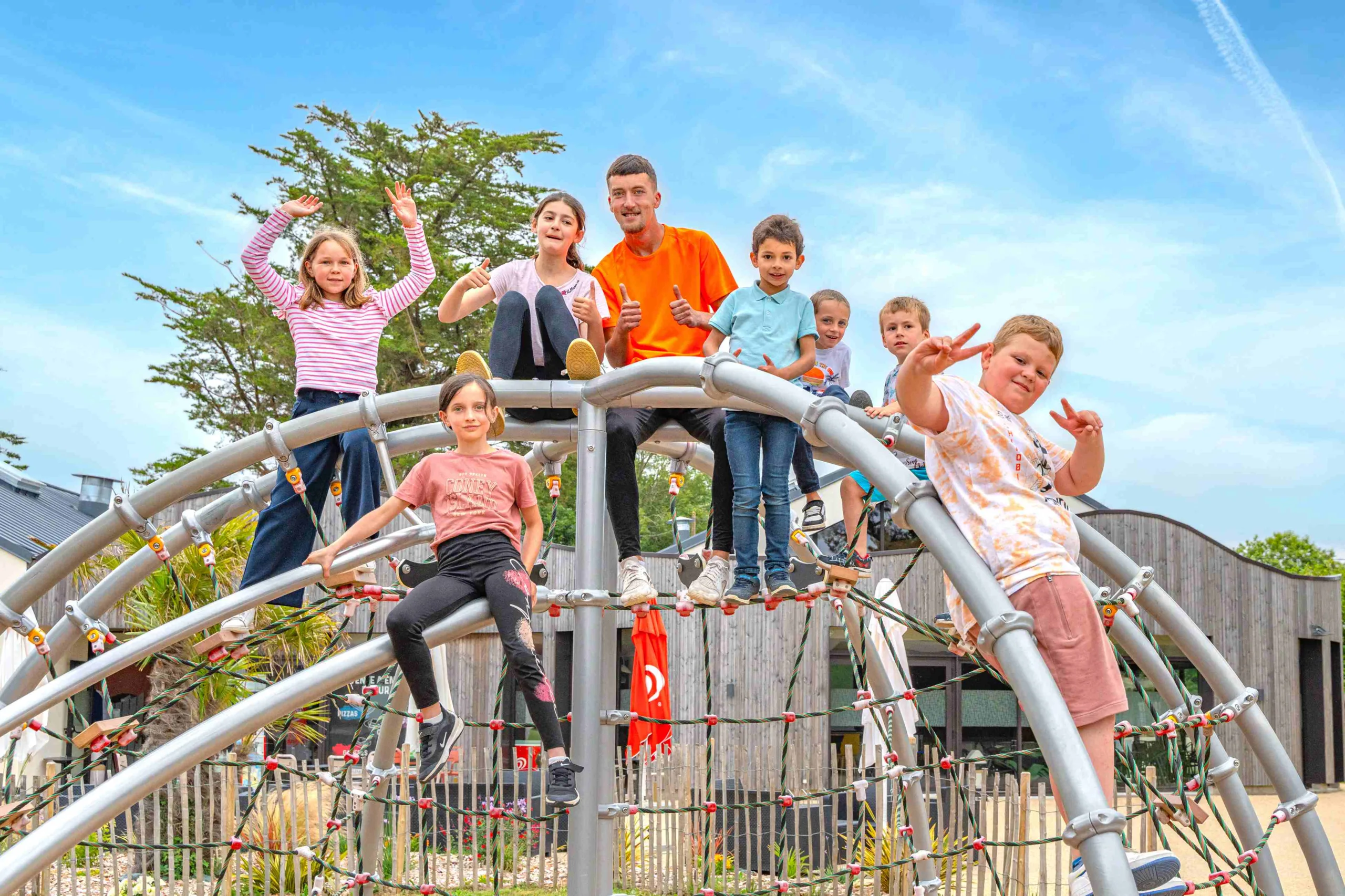 Enfants jouant sur une structure de jeu métallique.