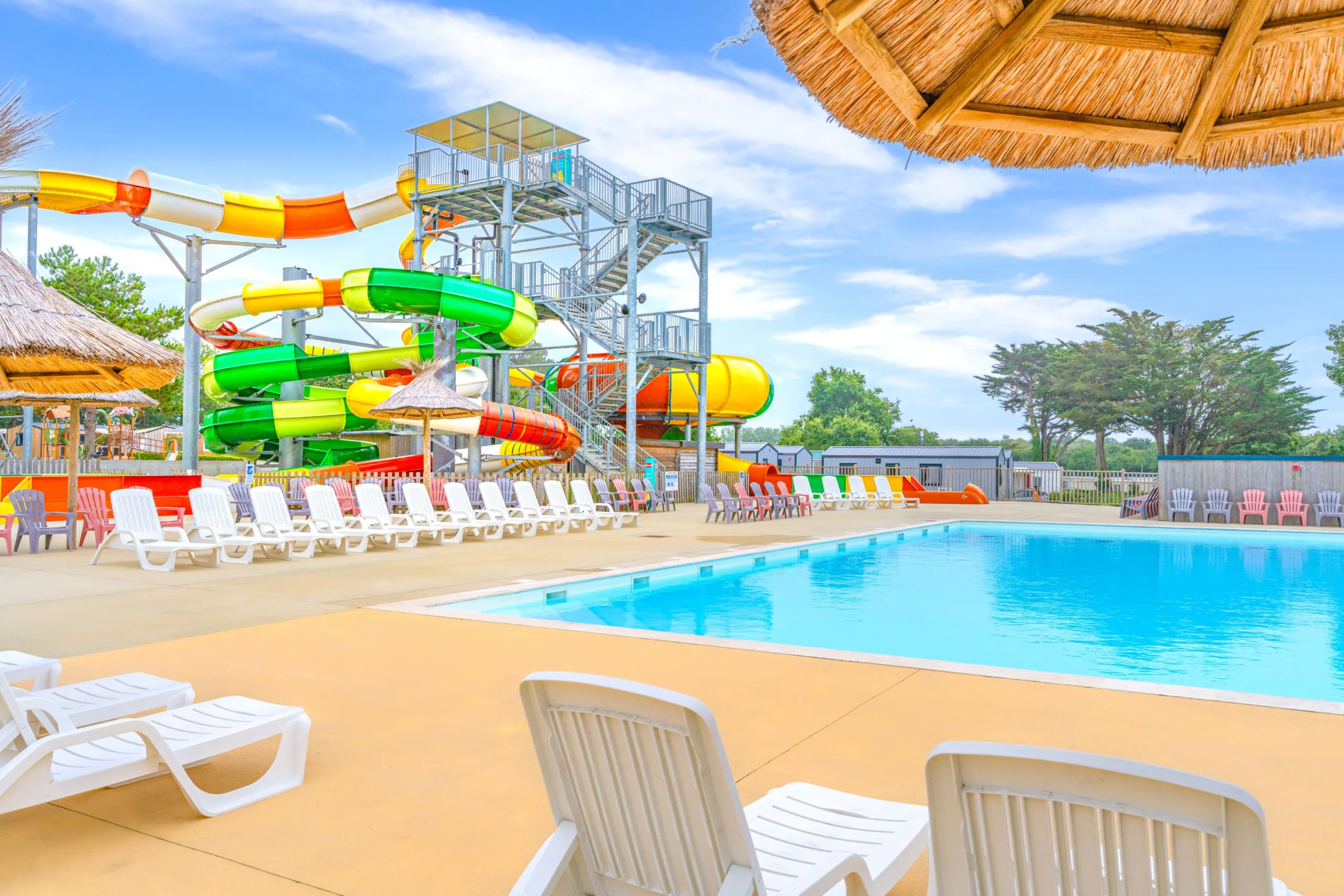 Piscine extérieure avec toboggans colorés.