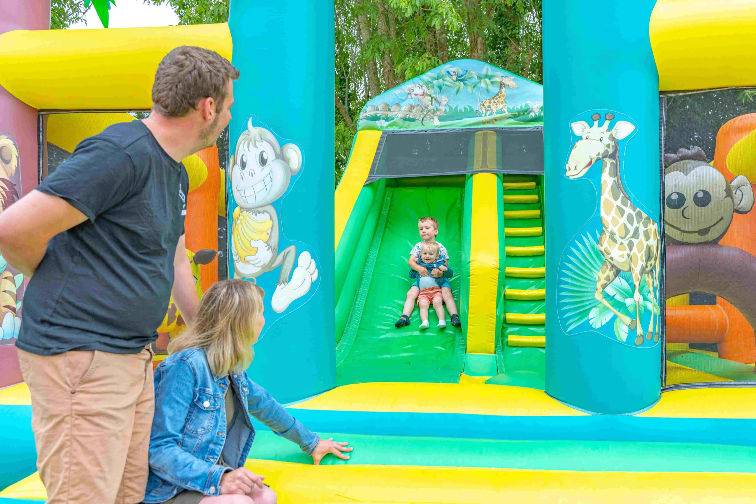 Enfants glissant sur un toboggan gonflable coloré.